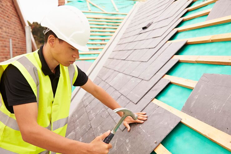Worker laying slate tiles