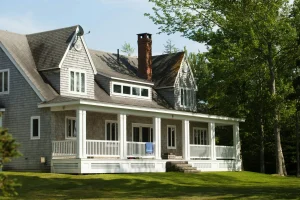Large house with shingled roof showing dark streaks and moss growth — image for "Storm Damage vs. Wear and Tear".