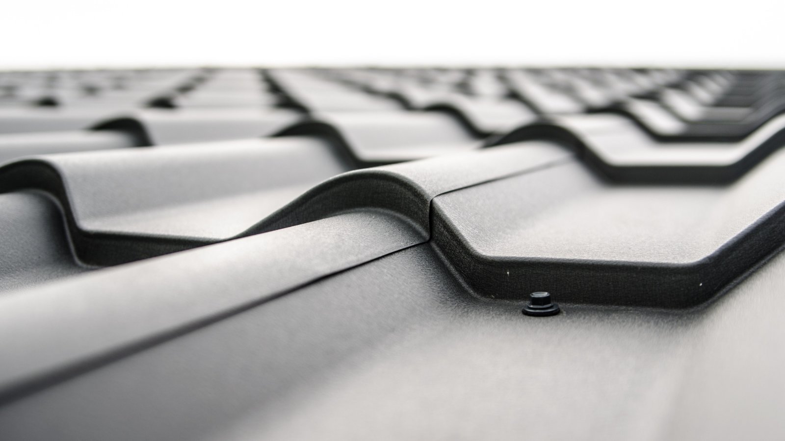 Close-up view of a metal roof with wavy design and rivets showing material detail