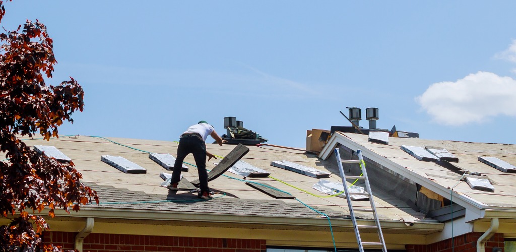 roofer preparing an underlayment surface on a residential roof