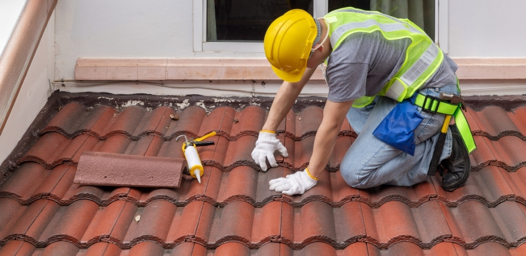 kneeling on a red tile roof