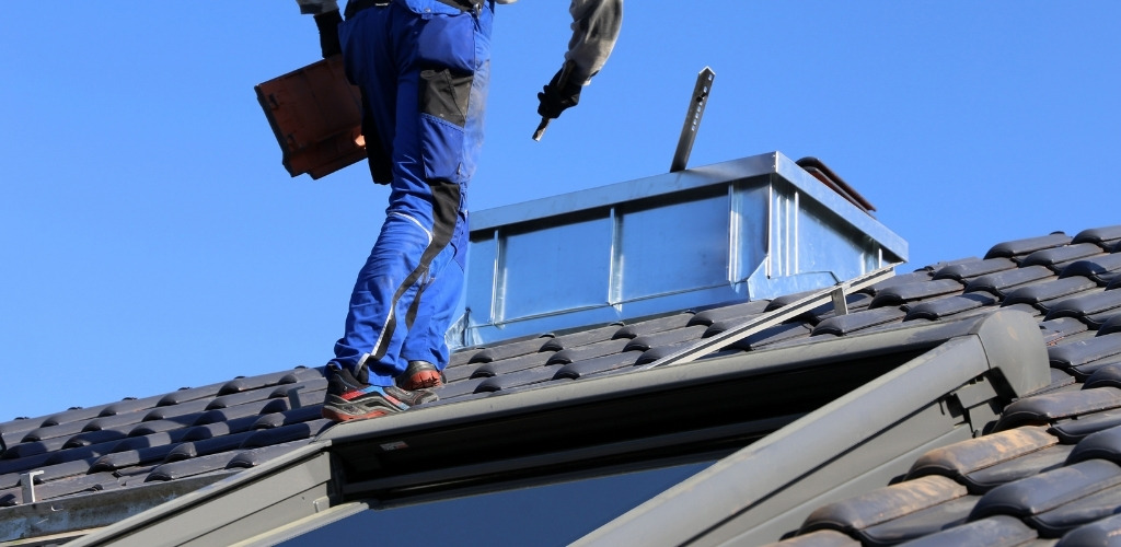 roofer working on a dark tiled roof